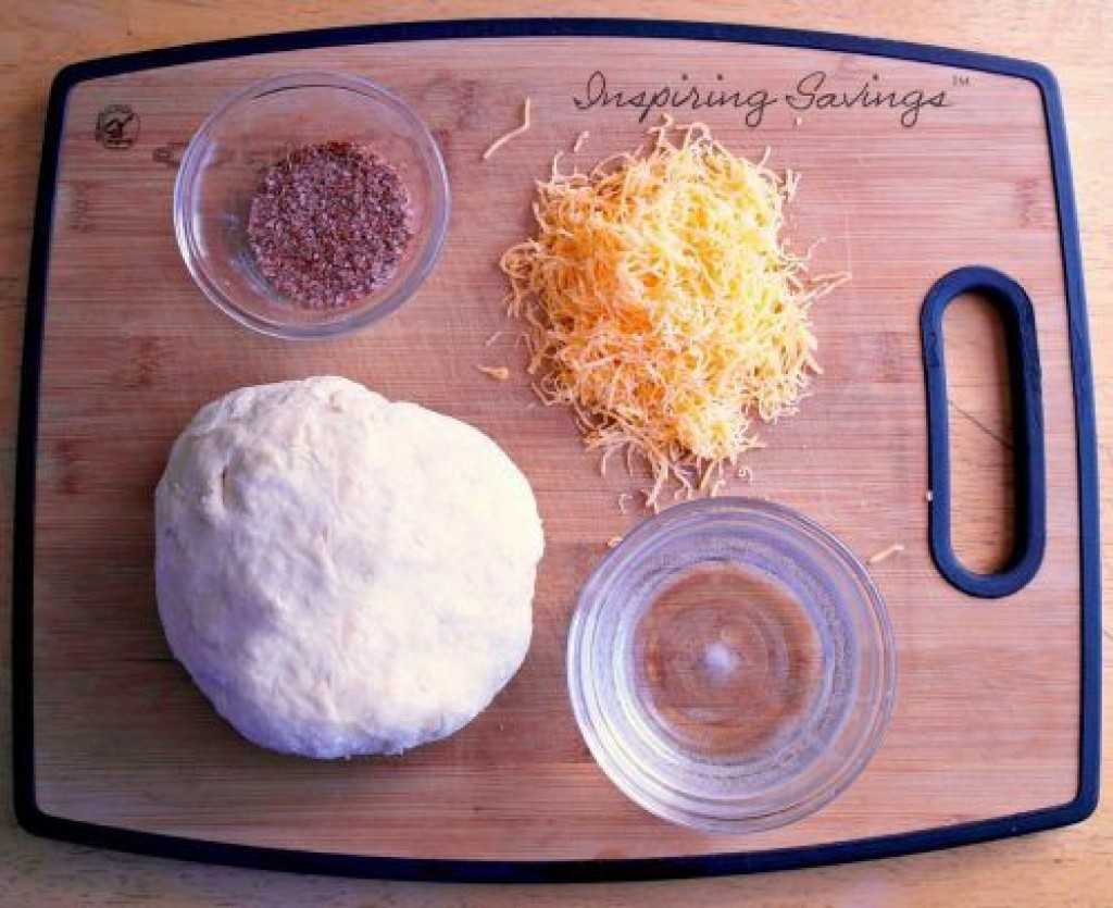 Ingredients on cutting board for stuffed pretzeled bread.