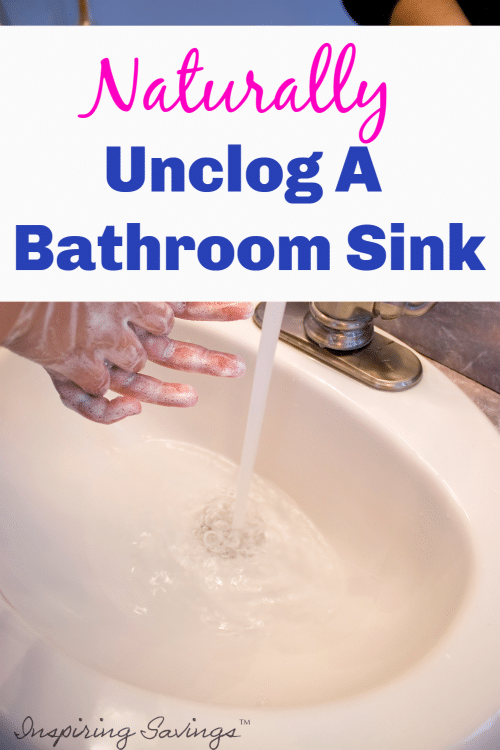 Woman washing hands in Bathroom sink that is clogged
