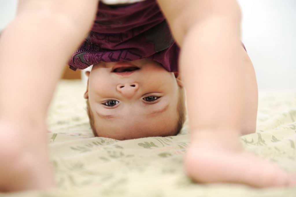 Baby Crawling in purple dress on floor