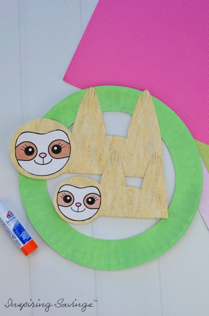 Adding baby sloth to mommy sloth on green paper plate wreath for Mother's Day Card