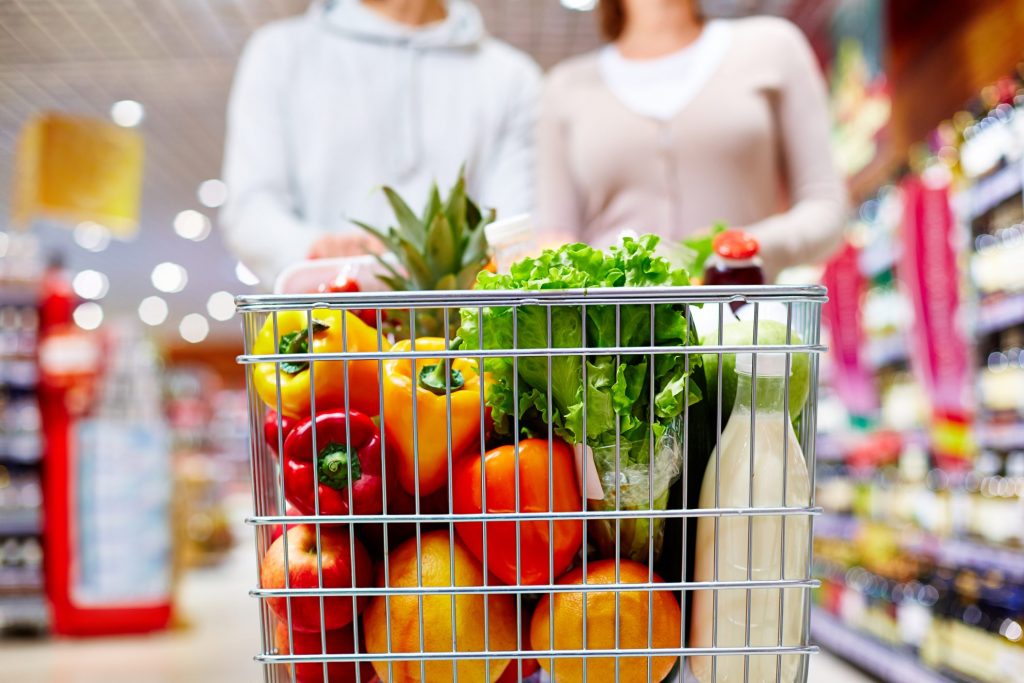 couple shopping in grocery store with grocery cart