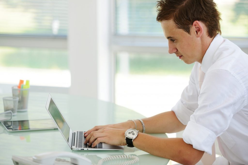 Man sitting at desk paying off bills