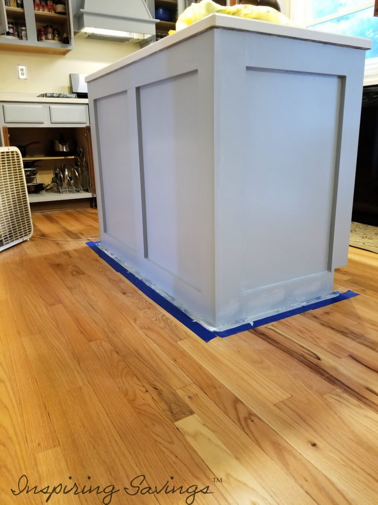 Painting Kitchen Cabinets - island taped off with new coat of Behr paint. adding a pop of color to kitchen