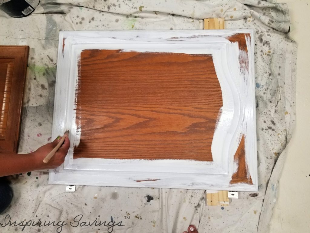 Priming kitchen cabinets fronts on drop cloth. Apply base coat of primer.