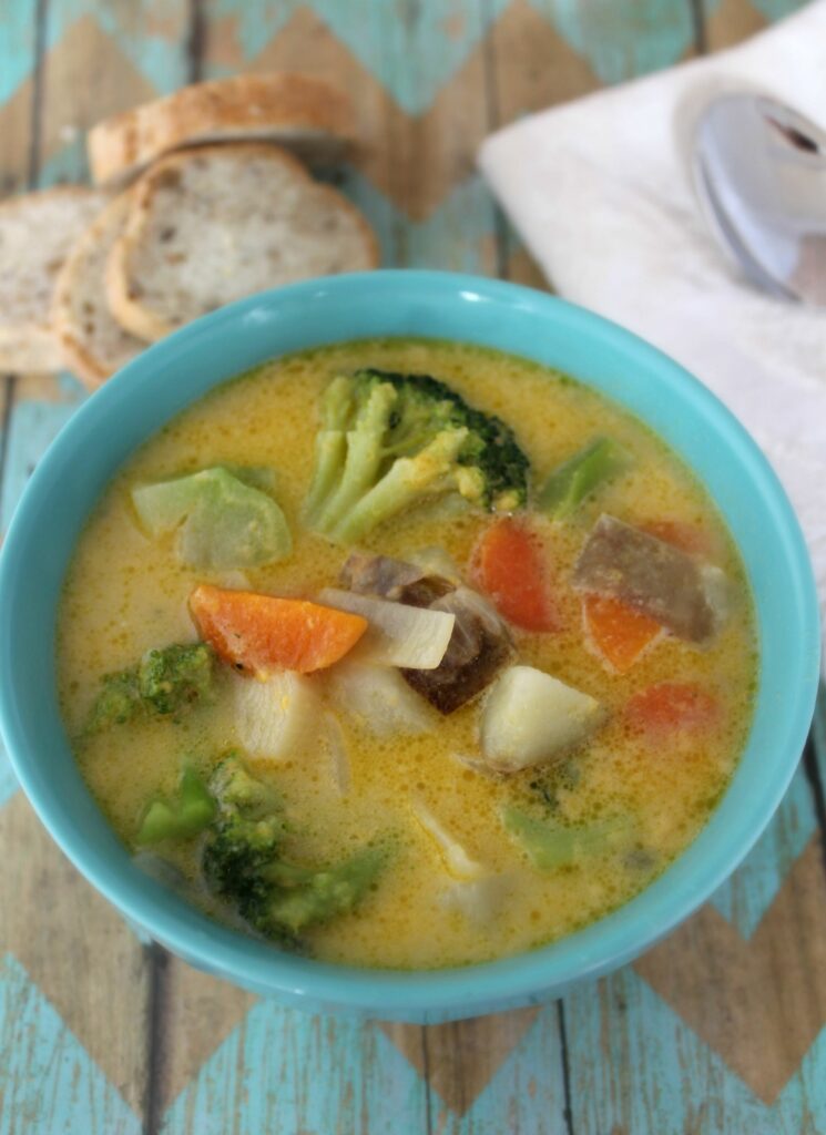 Soup in blue bowl on table with bread for dinner