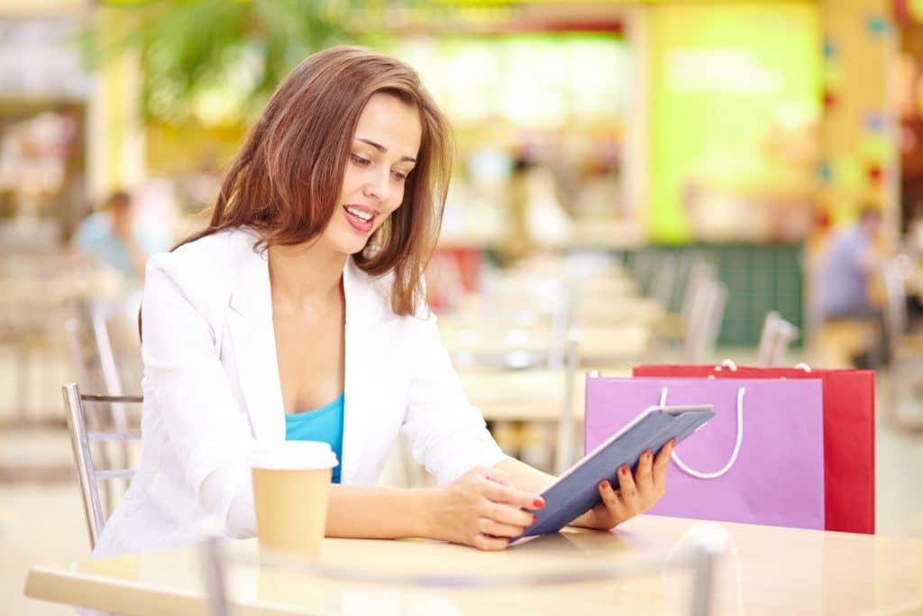 Woman shopping and looking for promotional code on tablet