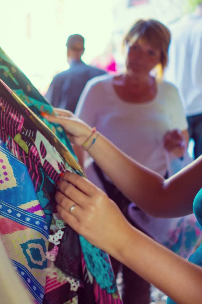 Shopping at a thrift store - woman looking through clothing rack