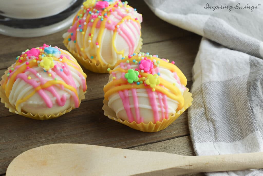 Spring hot Chocolate Bombs of Tabletop with wooden spoon and towel.