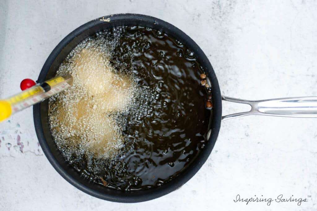 frying homemade chicken nuggets in sauce pan with heated oil.