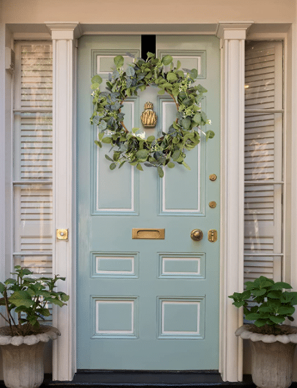 Eucalyptus wreath hanging on teal color door.