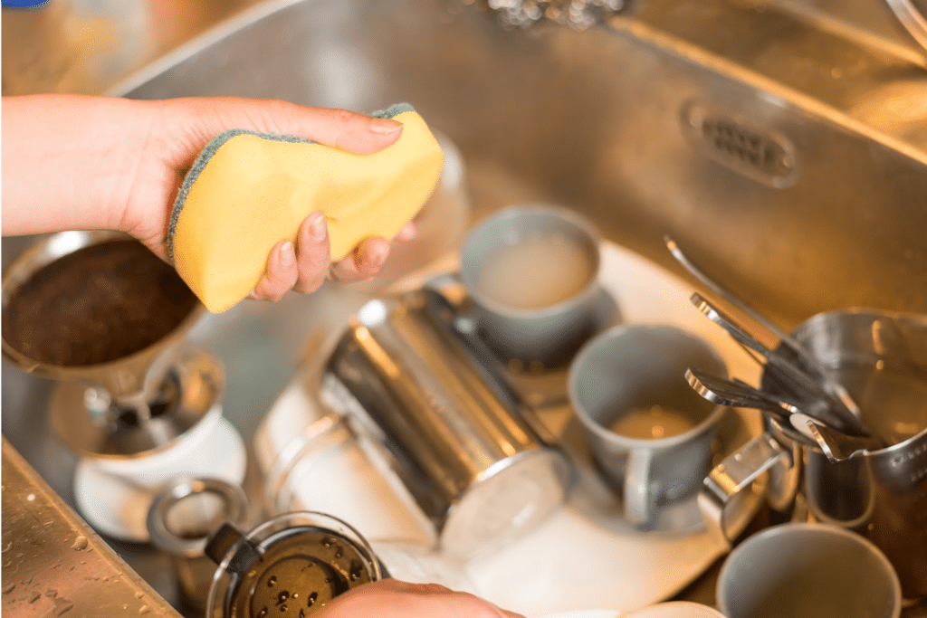 Sink filled with dirty dishes to be washed -Cleaning Mistakes you could be making