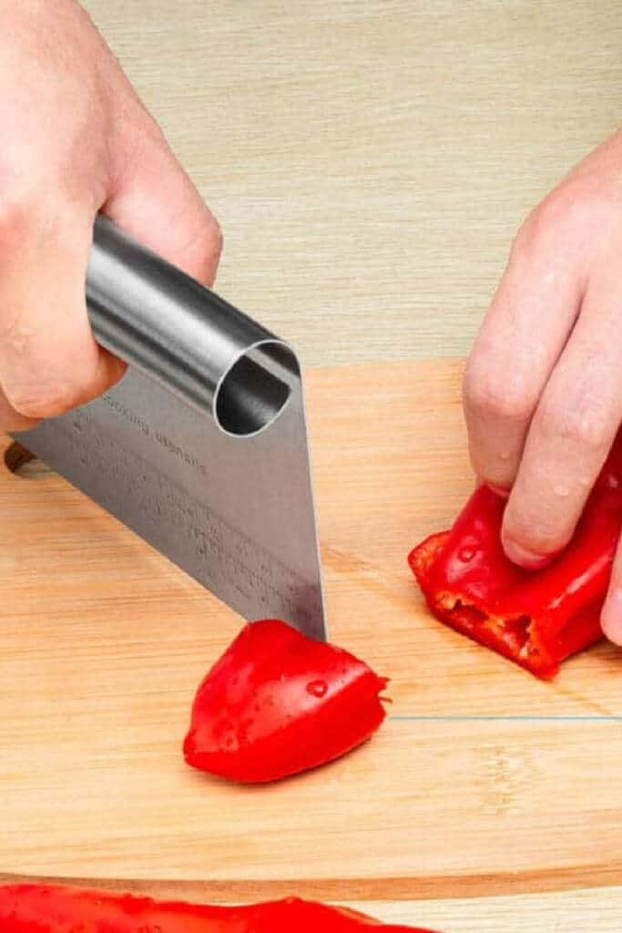 Bench slicer cutting red pepper on cutting board