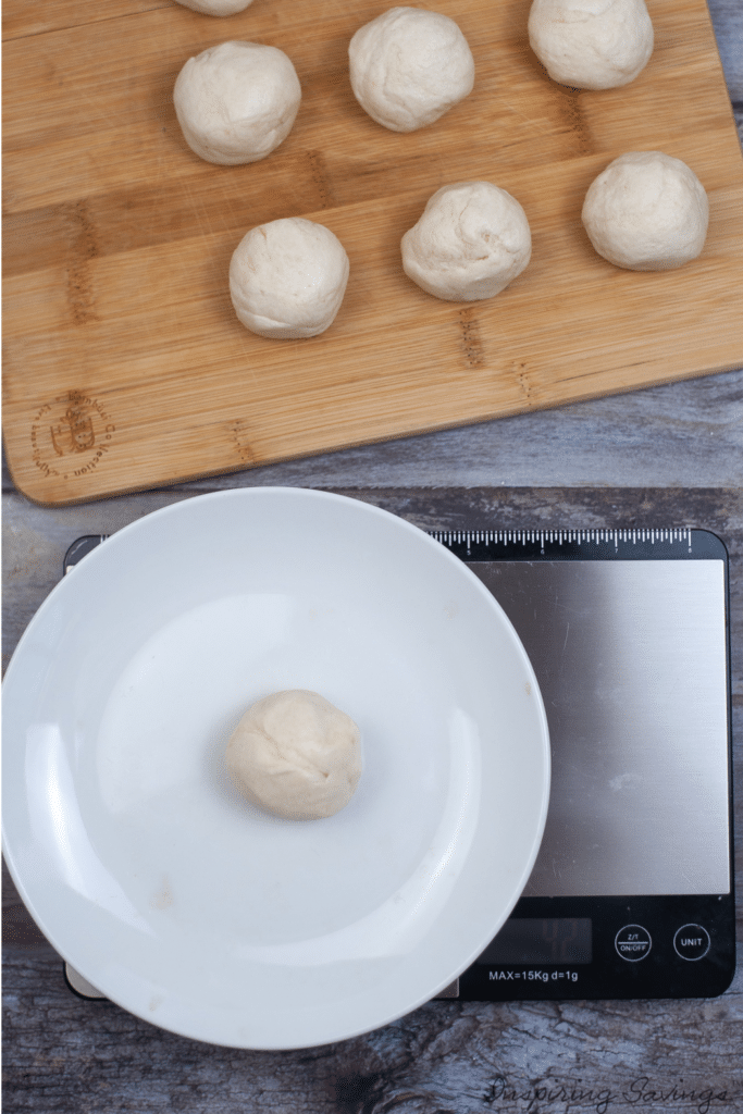 Measuring dough ball weights on wooden cutting board