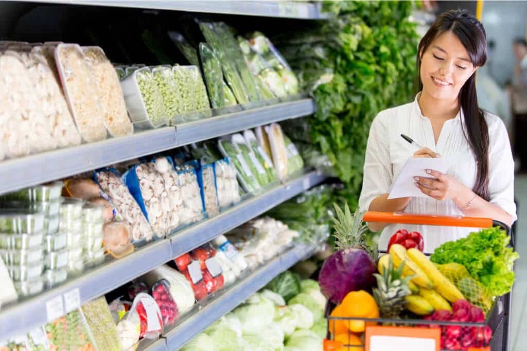 woman grocery shopping lower your grocery bill