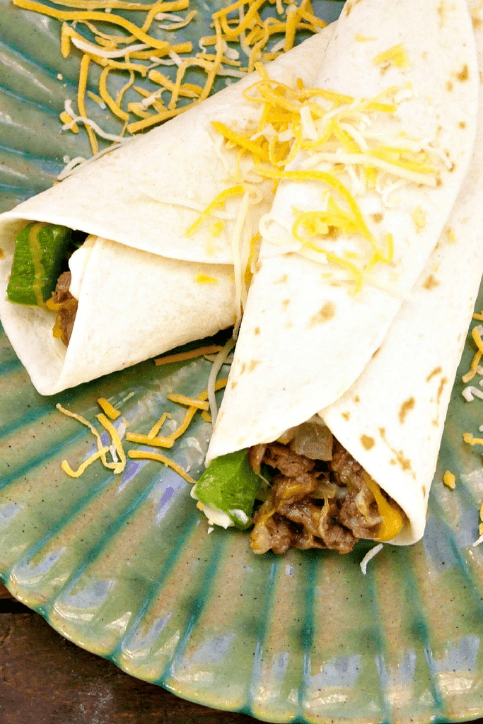 Adding cheese to steak and cheese wraps 1
