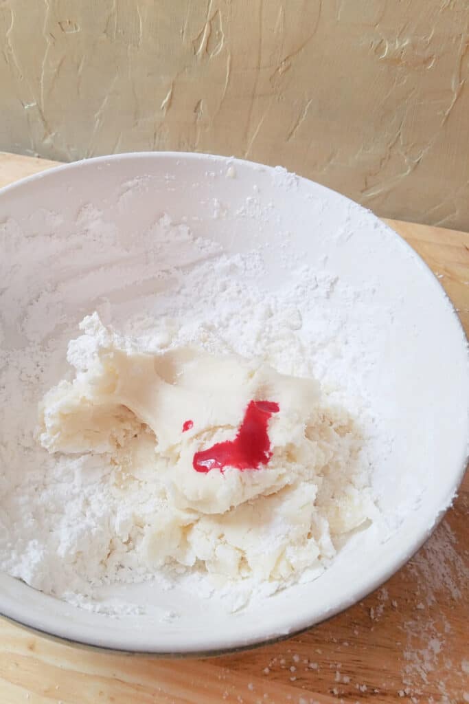 Adding red died to playdough in mixing bowl