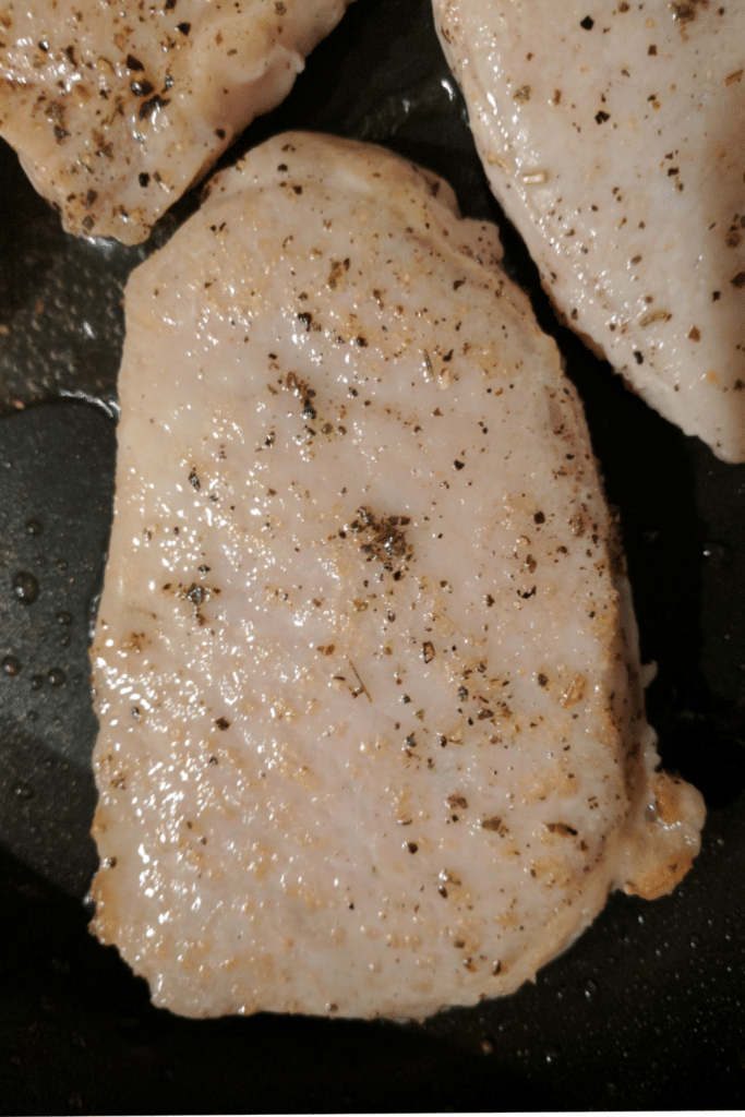 Browning pork chops in skillet - First side being cooked.