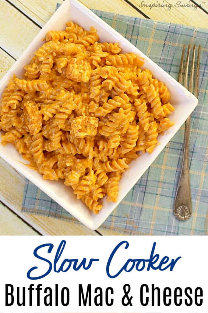 Buffalo Mac Cheese in white bowl on wooden background with blue stripped napkin