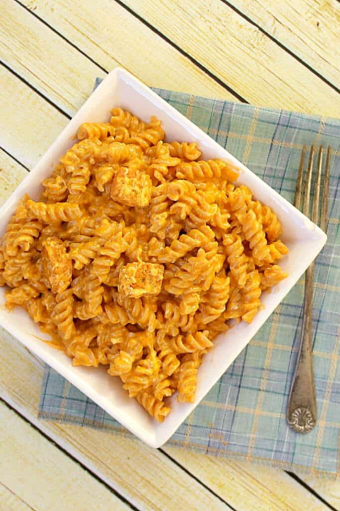 Buffalo Mac Cheese in white bowl on white wooden background