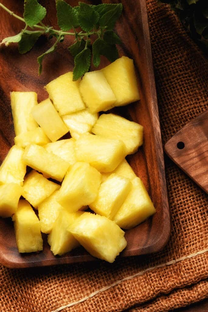 Cutting chunk Pineapple cut up on wooden tray