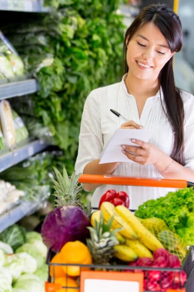 Woman checking shopping list spending on groceries