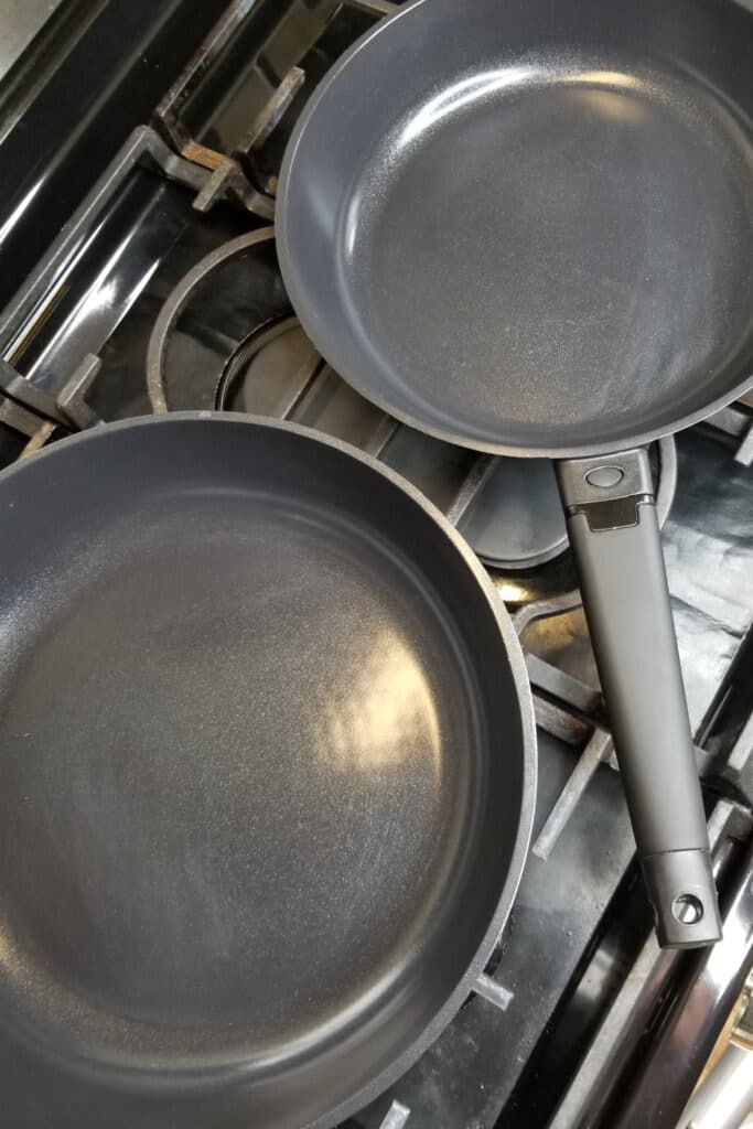 Correctly using nonstick pans - pictured two non-stick pans on cooktop