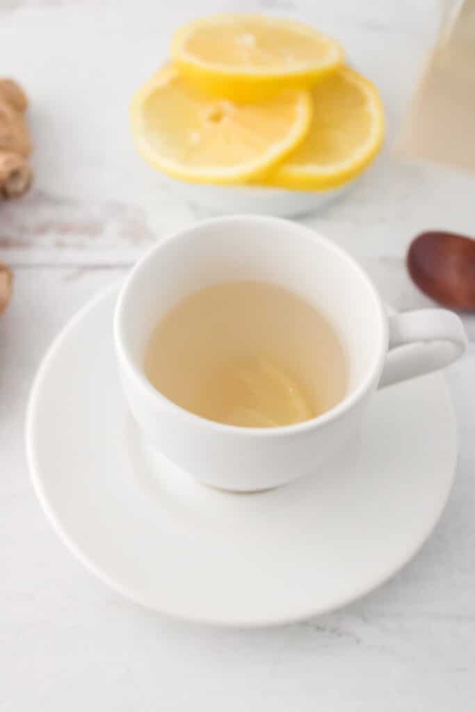 Ginger tea in white cup with slice of lemon