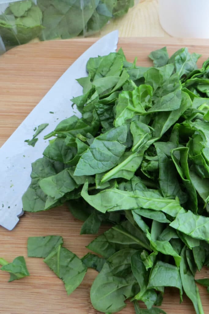 Rough Chopped Spinach on cutting board with large knife