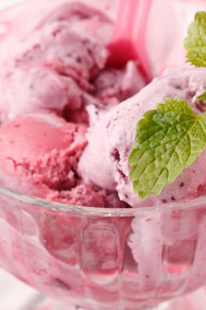 Strawberry Snow Ice Cream in clear glass bowl with a piece of mint
