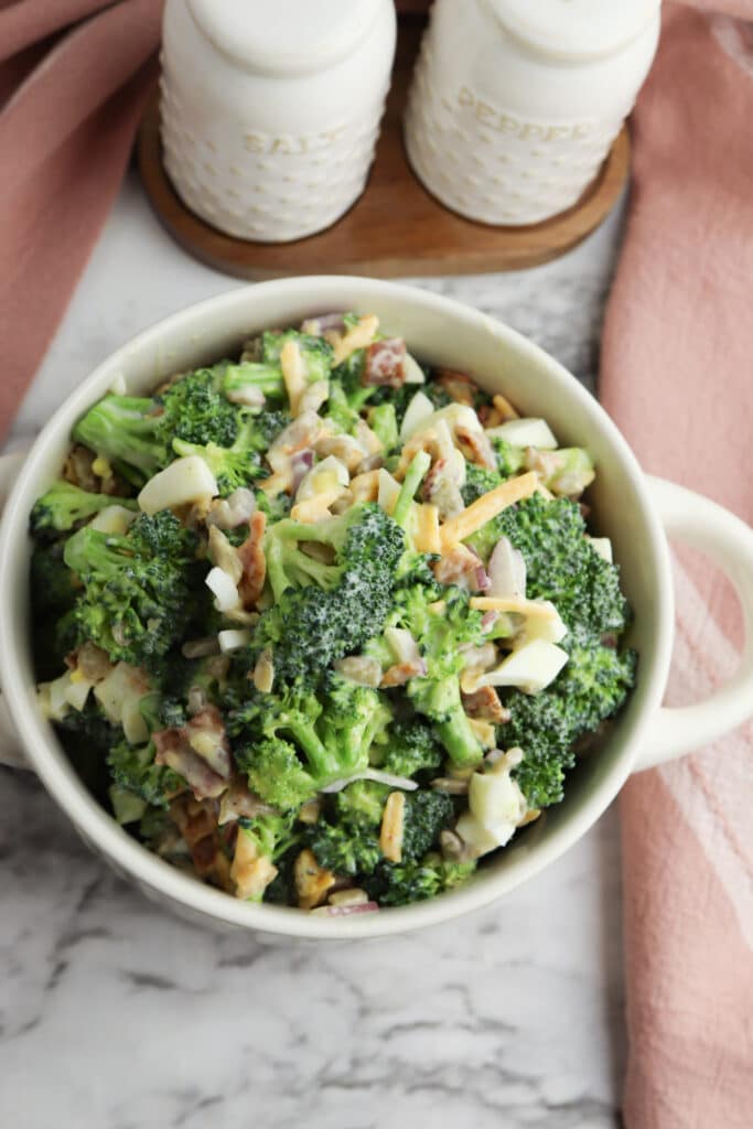 broccoli salad ready to serve in bowl with red cloth