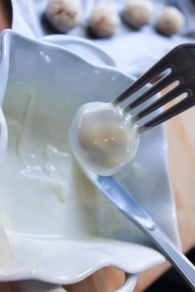 Dipping cake pop into white sugar