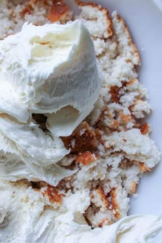 Frosting added to cake in large bowl