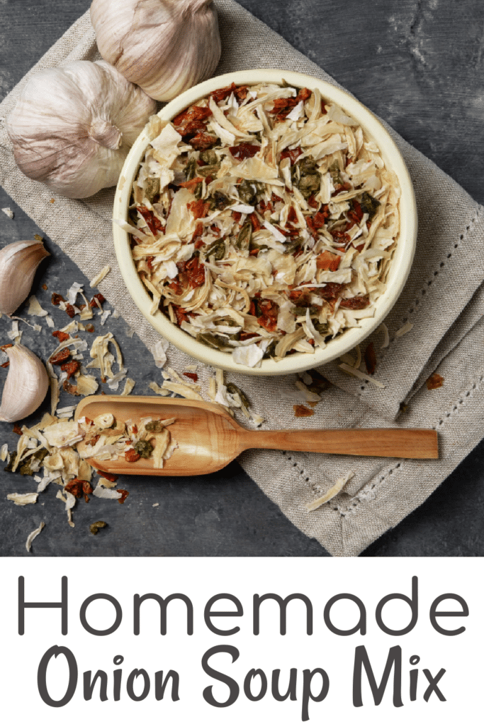 Homemade Onion Soup Mix in a bowl with fresh garlic bulbs and a grey napkin