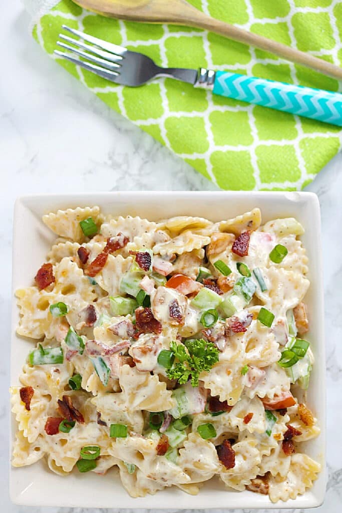 chicken bacon ranch pasta salad on marble backdrop in white serving bowl