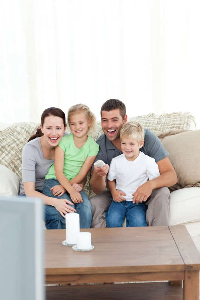 family watching tv together - sitting on couch