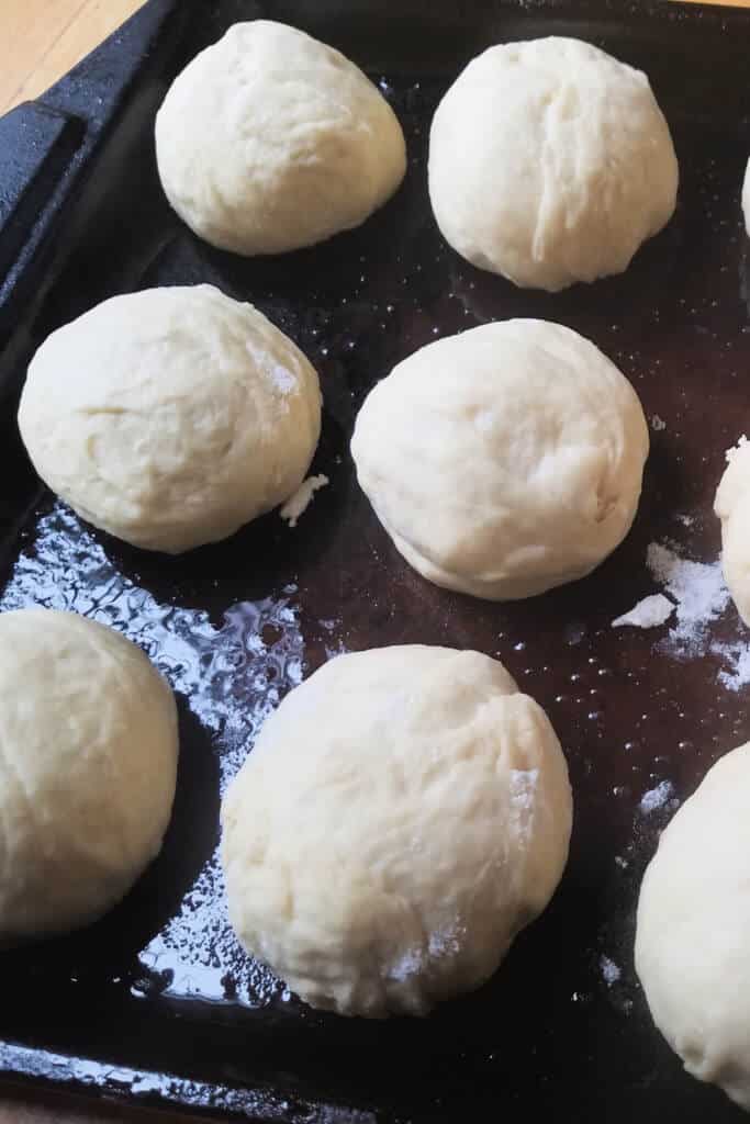 Dough balls on dark baking pan 1