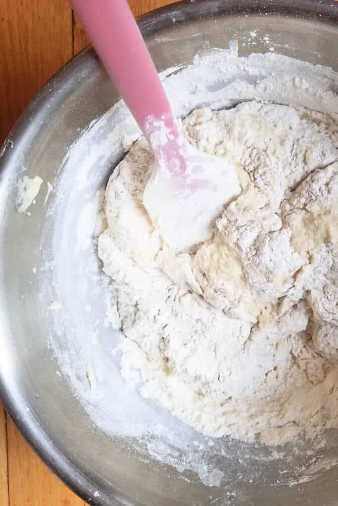 Mixing flour into wet ingredients for dinner rolls
