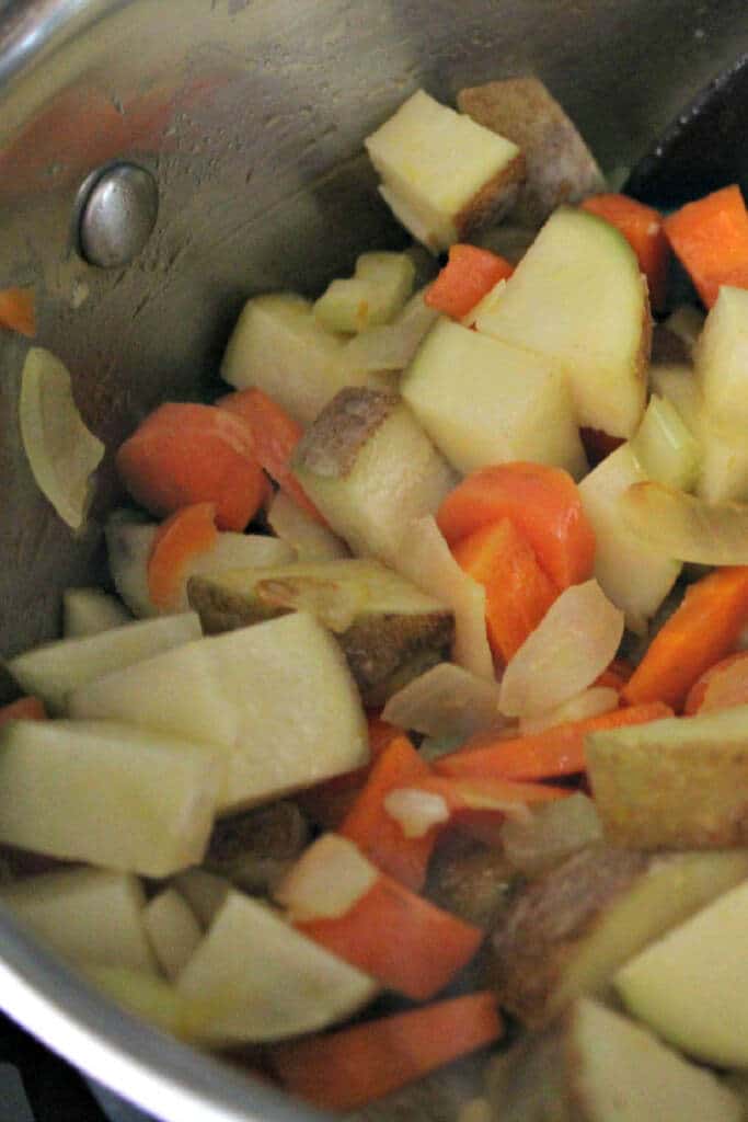 chopped potatoes carrots onions in pot