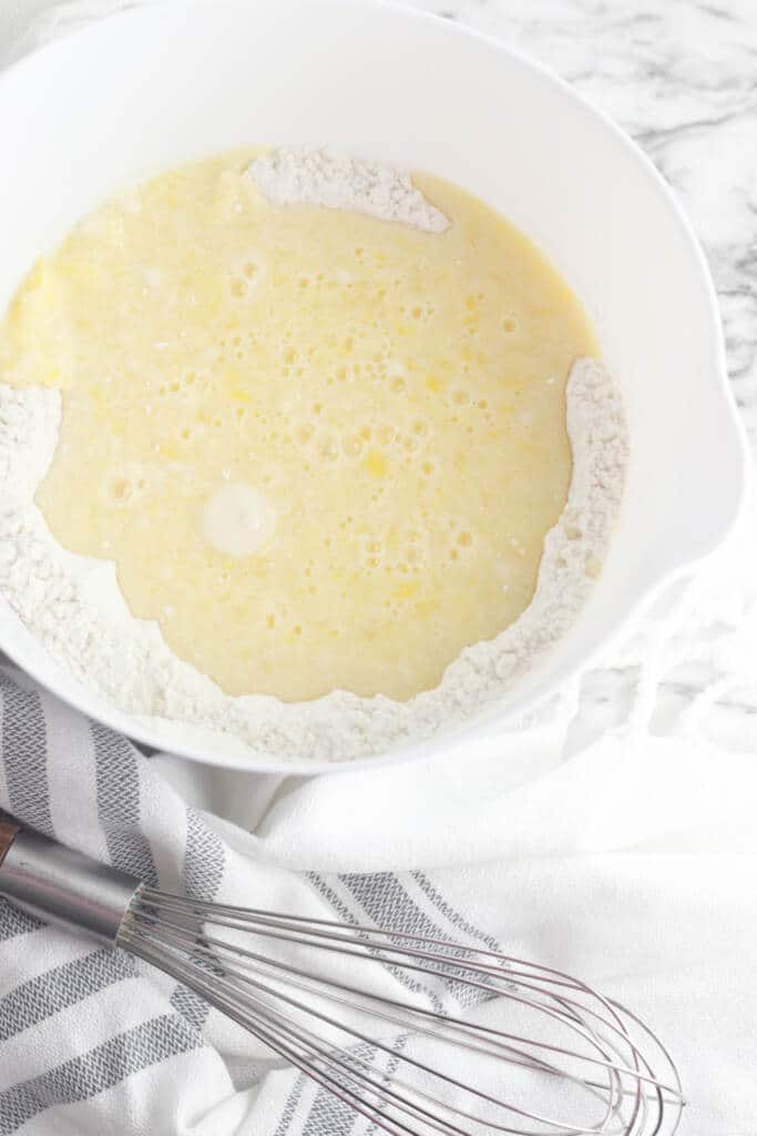 gluten free waffle batter in white mixing bowl with whisk