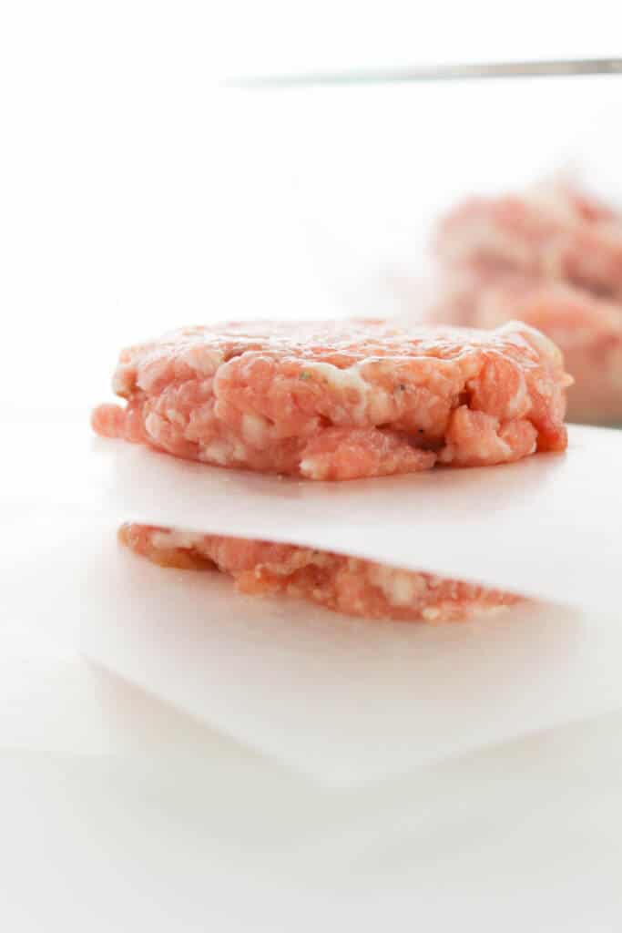 Breakfast sausage patties between parchment paper