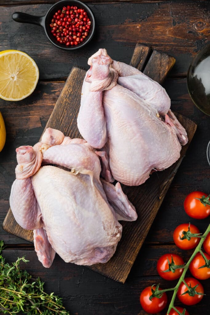 two whole roaster chickens being prepared for baking