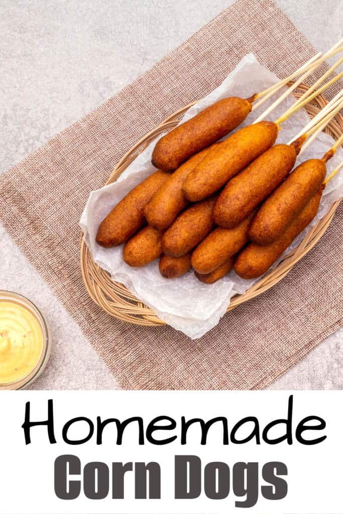 homemade corn dogs recipe - close up image of corn dogs on table in basket with parchment paper