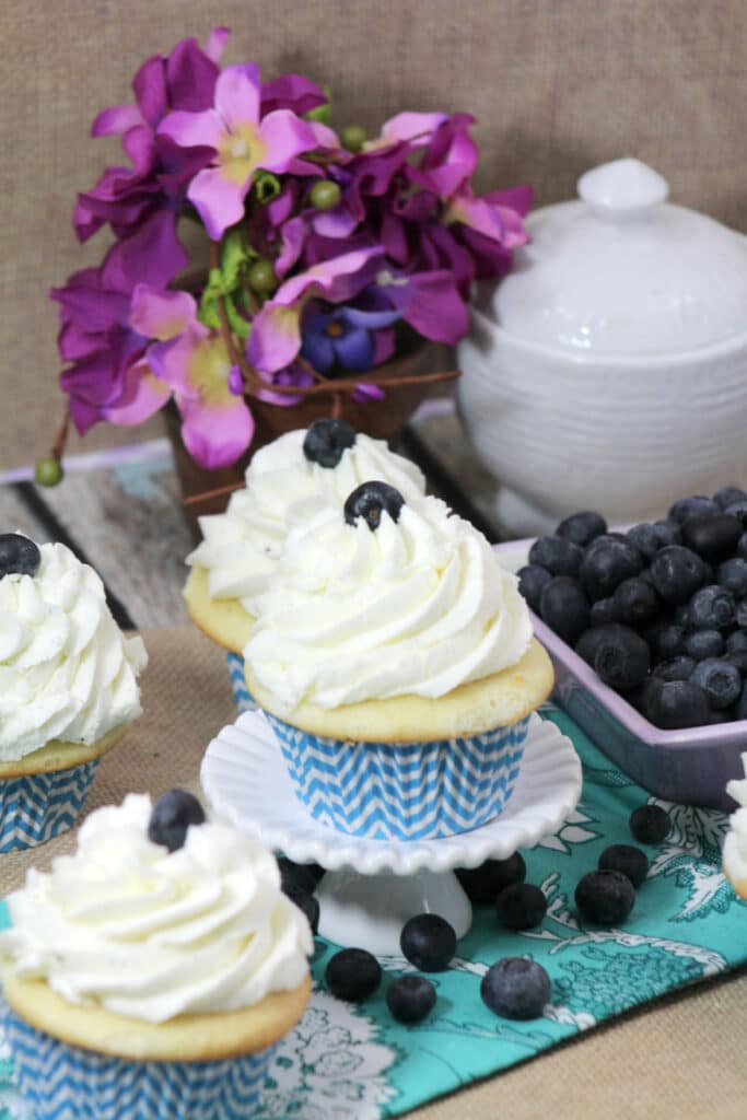 blueberry cupcakes with filling displayed on table with loose fresh blueberries