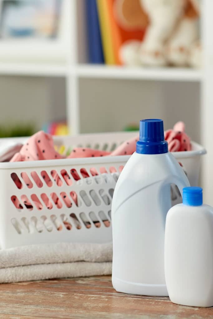 Reducing Static cling on clothing - pictured laundry basket full of clothing and two bottles of fabric softener