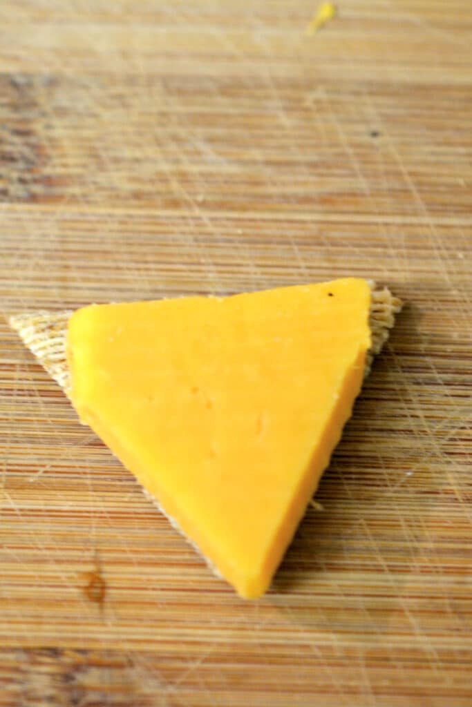 Cut Cheddar Cheese to fit crackers in a triangle form