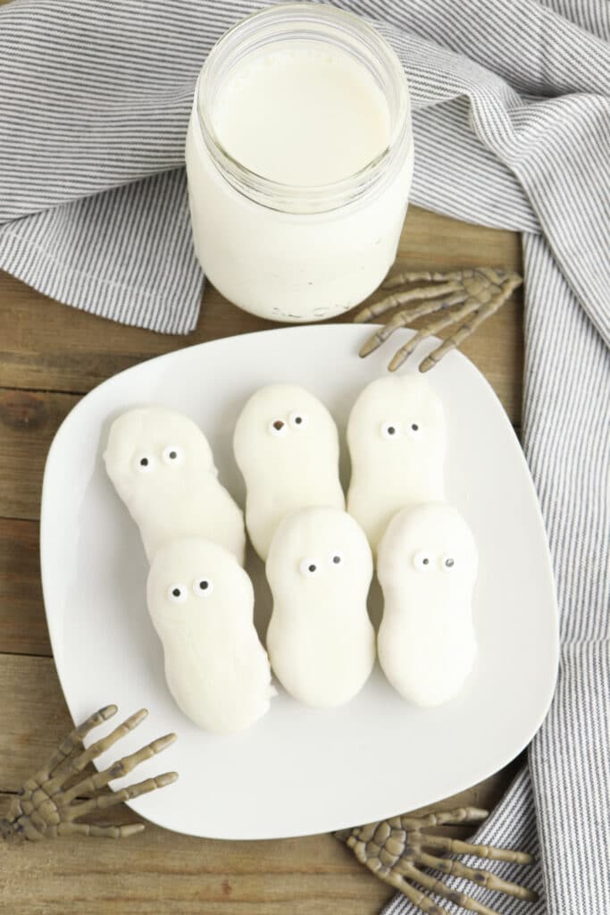 Nutter Butter ghost cookies with candy eye balls - completed on wooden background on white plate