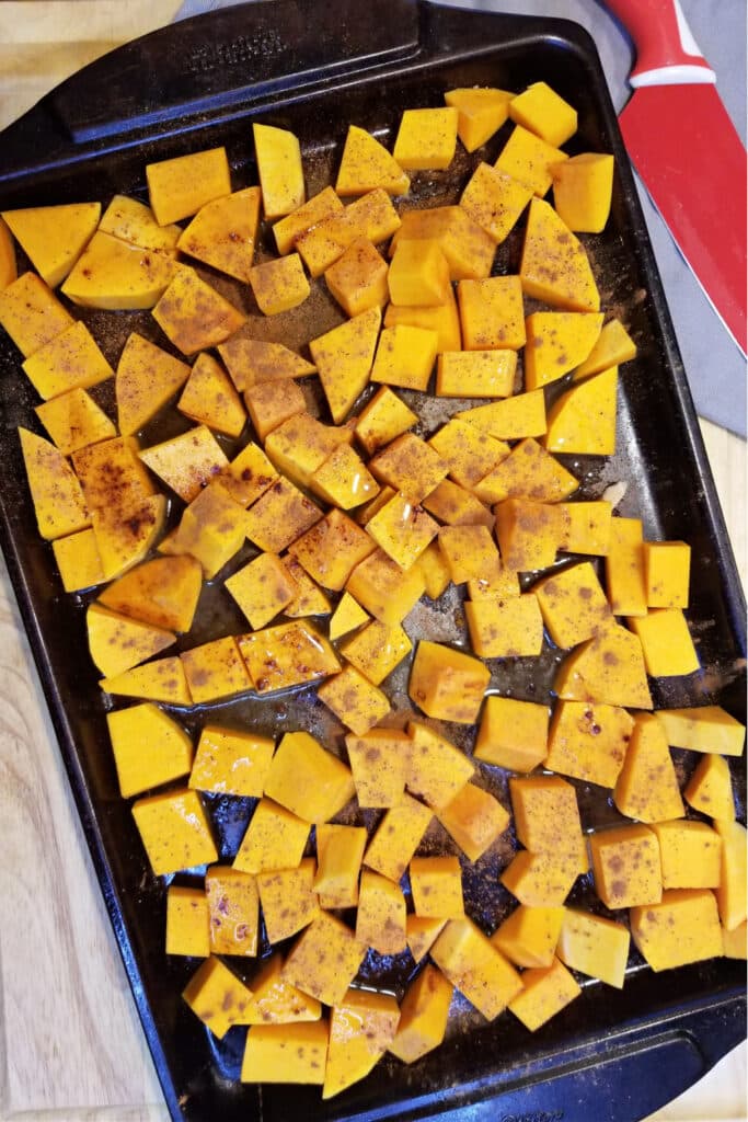 chopped and seasoned butternut squash on sheet baking pan