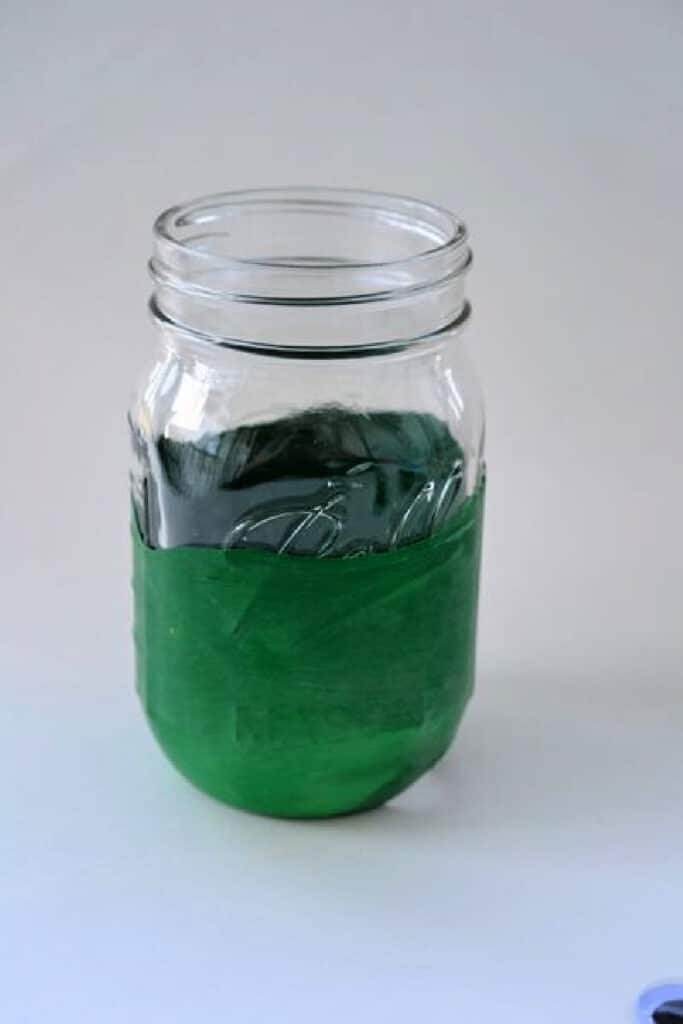 green balloon stretched over jar