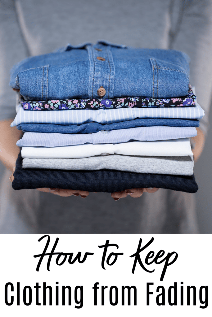 keep clothing from fading - woman holding a folded pile of laundry in hands