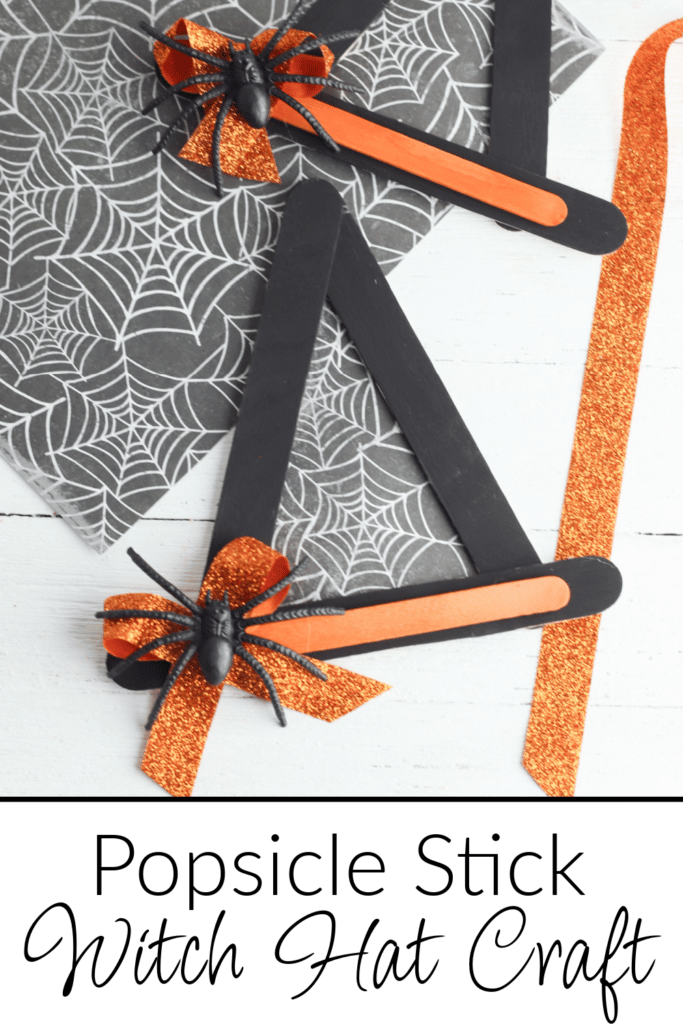 popsicle stick witch hat craft on white background and spiderweb construction paper